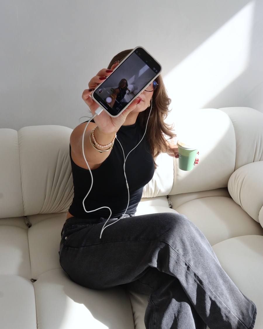 Content creation selfie with phone and iced coffee