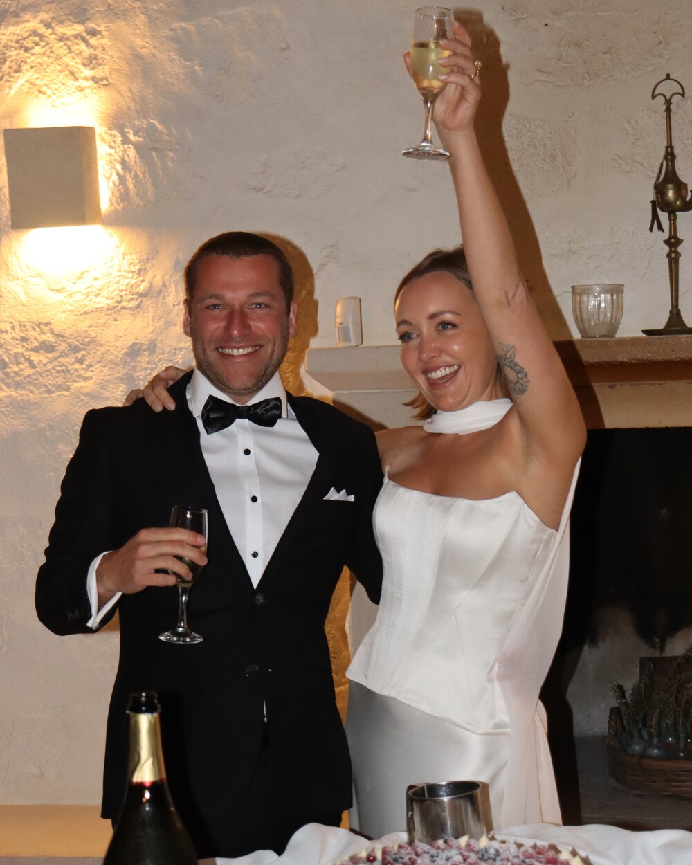 Bride raising a champagne toast beside the groom